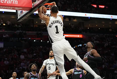| Photo: AP/Lynne Sladky : San Antonio Spurs forward Victor Wembanyama (1) dunks over Miami Heat center Bam Adebayo, right, during the first half of an NBA basketball game in Miami.