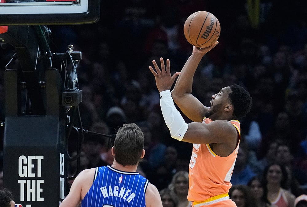 | Photo: AP/Sue Ogrocki : Cleveland Cavaliers guard Donovan Mitchell, right, shoots in front of Orlando Magic forward Moritz Wagner, left, in the second half of an NBA basketball game in Cleveland.