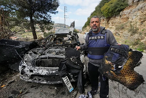 | Photo: AP/Mohammed Zaatari : A journalist carries burned safety gear, following an Israeli airstrike on a car that killed Hezbollahs al-Manar TV correspondent Ali Shoeib, Beiruts based Al-Mayadeen TV reporter Fatima Ftouni and her brother, video journalist Mohammed Ftouni, in the town of Jezzine, south Lebanon.