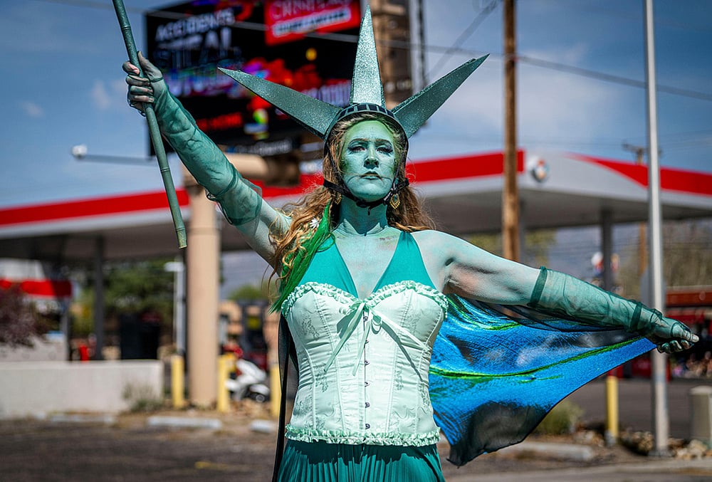 | Photo: Jessica Baca/The Albuquerque Journal via AP : Carrie Chavez, dressed as the Statue of Liberty, participates in a No Kings march on Montgomery Blvd in Albuquerque, New Mexico.