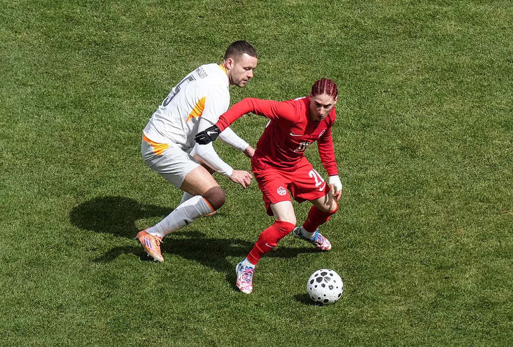 | Photo: Chris Young/The Canadian Press via AP : Canadas Marcelo Flores turns away from Icelands Sverrir Ingi Ingason during the second half of an international friendly soccer match in Toronto.