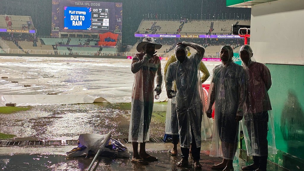 AP : Ground staff stand on covers as it rains during the Indian Premier League match between Kolkata Knight Riders and Punjab Kings in Kolkata.