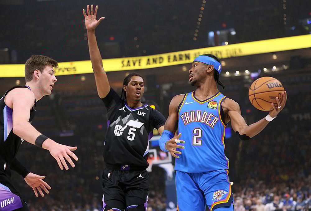 | Photo: AP/Nate Billings : Oklahoma City Thunder guard Shai Gilgeous-Alexander (2) looks to pass the ball away from Utah Jazz forwards Cody Williams (5) and Kyle Filipowski, left, during the first half of an NBA basketball game in Oklahoma City. 