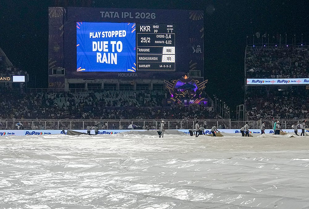 | Photo: PTI/Manvender Vashist Lav : Ground staff cover the ground during rain interruption in an Indian Premier League (IPL) 2026 cricket match between Kolkata Knight Riders and Punjab Kings at Eden Gardens, in Kolkata