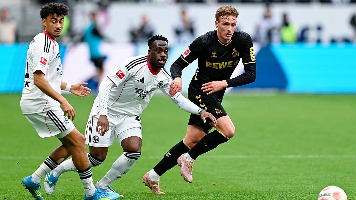 | Photo: dpa/Uwe Anspach via AP : Cologne's Sebastian Sebulonsen, right, and Frankfurt's Nathaniel Brown, left, and Arnaud Kalimuendo battle for the ball during the German Bundesliga soccer match between Eintracht Frankfurt and 1. FC Cologne in Frankfurt, Germany, Sunday, April 5, 2026.