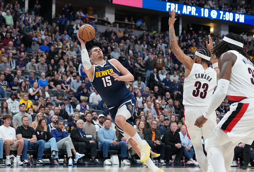 | Photo: AP/David Zalubowski : Denver Nuggets center Nikola Jokić, left, falls as he puts up a shot after being fouled by Portland Trail Blazers forward Toumani Camara, back right, as center Robert Williams III looks on in the second half of an NBA basketball game in Denver. 