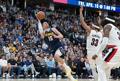 | Photo: AP/David Zalubowski : Denver Nuggets center Nikola Jokić, left, falls as he puts up a shot after being fouled by Portland Trail Blazers forward Toumani Camara, back right, as center Robert Williams III looks on in the second half of an NBA basketball game in Denver.