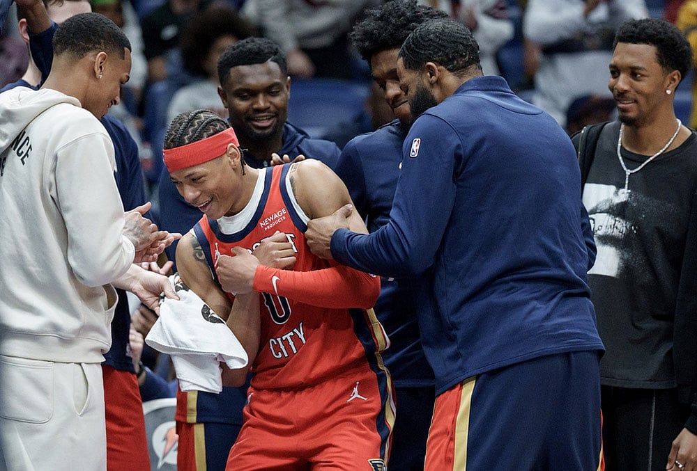 | Photo: AP/Matthew Hinton : New Orleans Pelicans guard Jeremiah Fears (0) is congratulated by teammates including guard Dejounte Murray, left, forward Zion Williamson, forward Herbert Jones, guard Saddiq Bey, and forward Trey Murphy III during the second half after Fears scored 40 points against the Utah Jazz during an NBA basketball game in New Orleans.