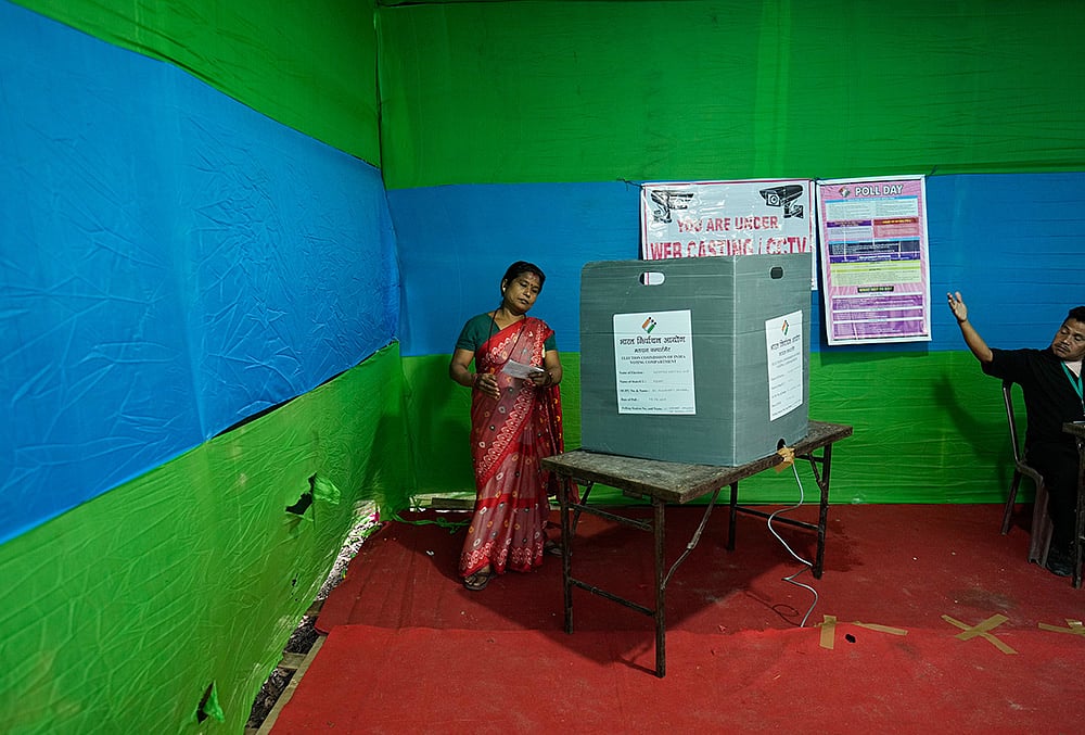 | Photo: AP/Anupam Nath : A polling official, right, instructs a woman to leave after she cast her vote at a polling center during the Assam state election in Guwahati | Rep Image |