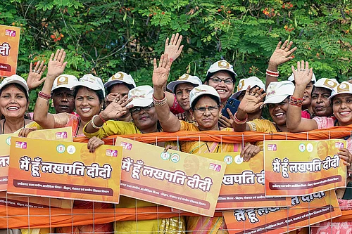 Photo: IMAGO/ANI News : People holding posters of Lakhpati Didi Scheme posters during a roadshow of Prime Minister Narendra Modi, in Nava Raipur, Chattisgarh
