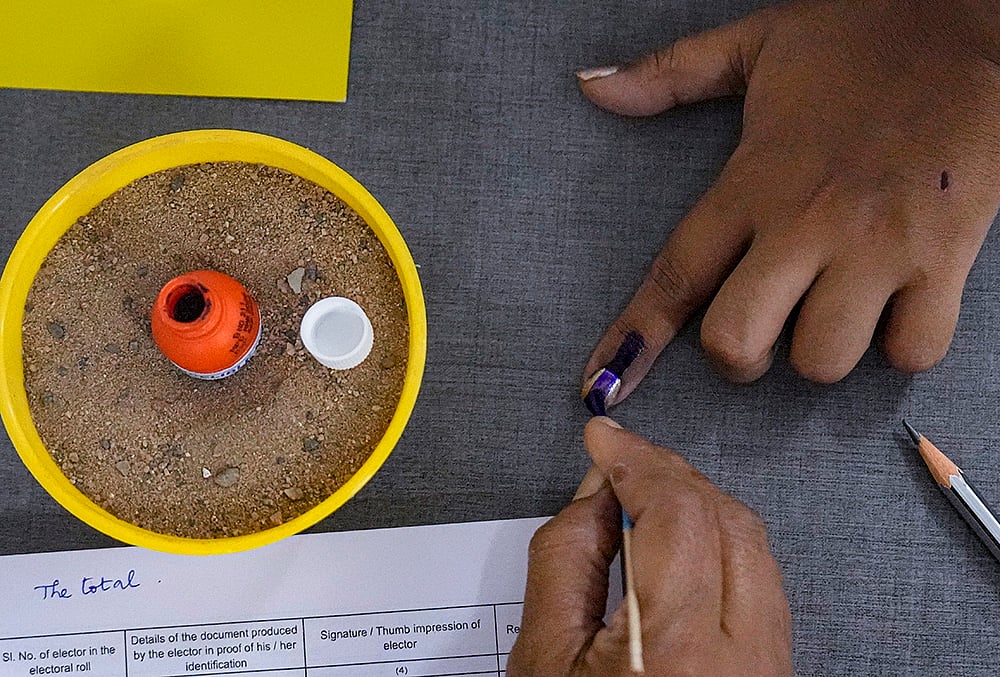 | Photo: PTI/R Senthilkumar : A voter gets her finger marked with indelible ink while casting vote during the Puducherry Assembly elections, at a polling station in Puducherry.