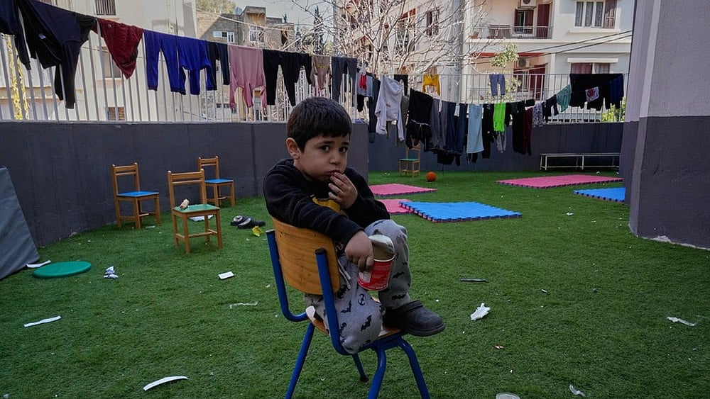 | Photo: AP/Hussein Malla : A displaced boy who fled Israeli strikes in southern Lebanon with his family sits on the backyard school that turned into a shelter in Beirut, Lebanon, Tuesday, March 10, 2026. 