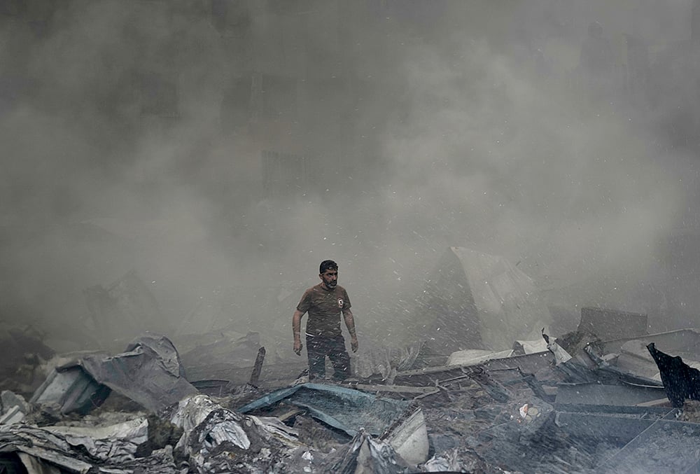 | Photo: AP/Bilal Hussein : A first responder emerges through the smoke at the site of an Israeli airstrike that struck an apartment building in Beirut, Lebanon, Wednesday, April 8, 2026. 