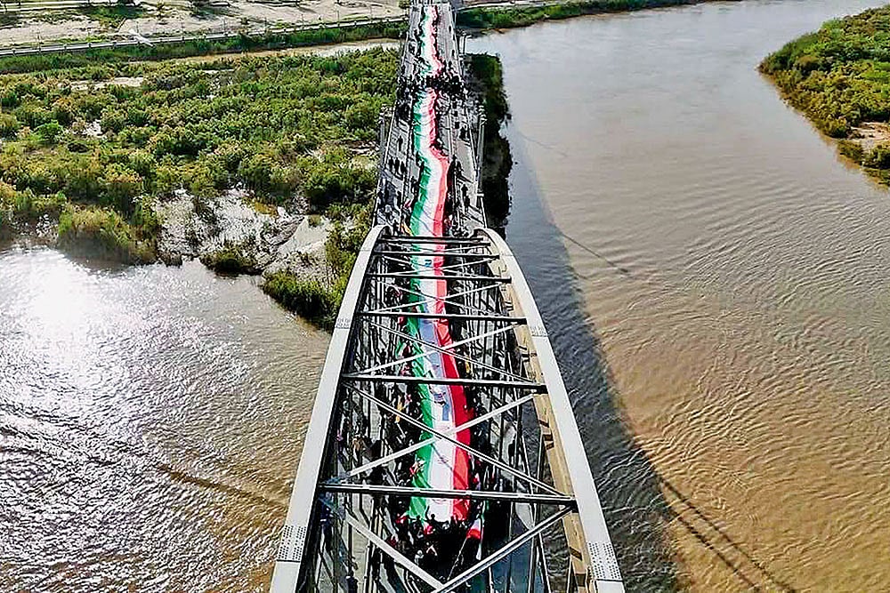 | Courtesy: X : ‘We Defend Iran With our Lives’: The people of Ahvaz form a human chain on the city’s old bridge standing firm against any attack by Trump.