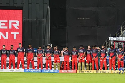 | Photo: PTI/Kunal Patil : Players of Royal Challengers Bengaluru observe a moment of silence in memoriam of singing legend Asha Bhosle, before an Indian Premier League (IPL) 2026 T20 cricket match between Mumbai Indians and Royal Challengers Bengaluru, in Mumbai, Maharashtra. Bhosle, Indias beloved singing icon, died at the age of 92 on Sunday following multiple organ failure, doctors treating her said.