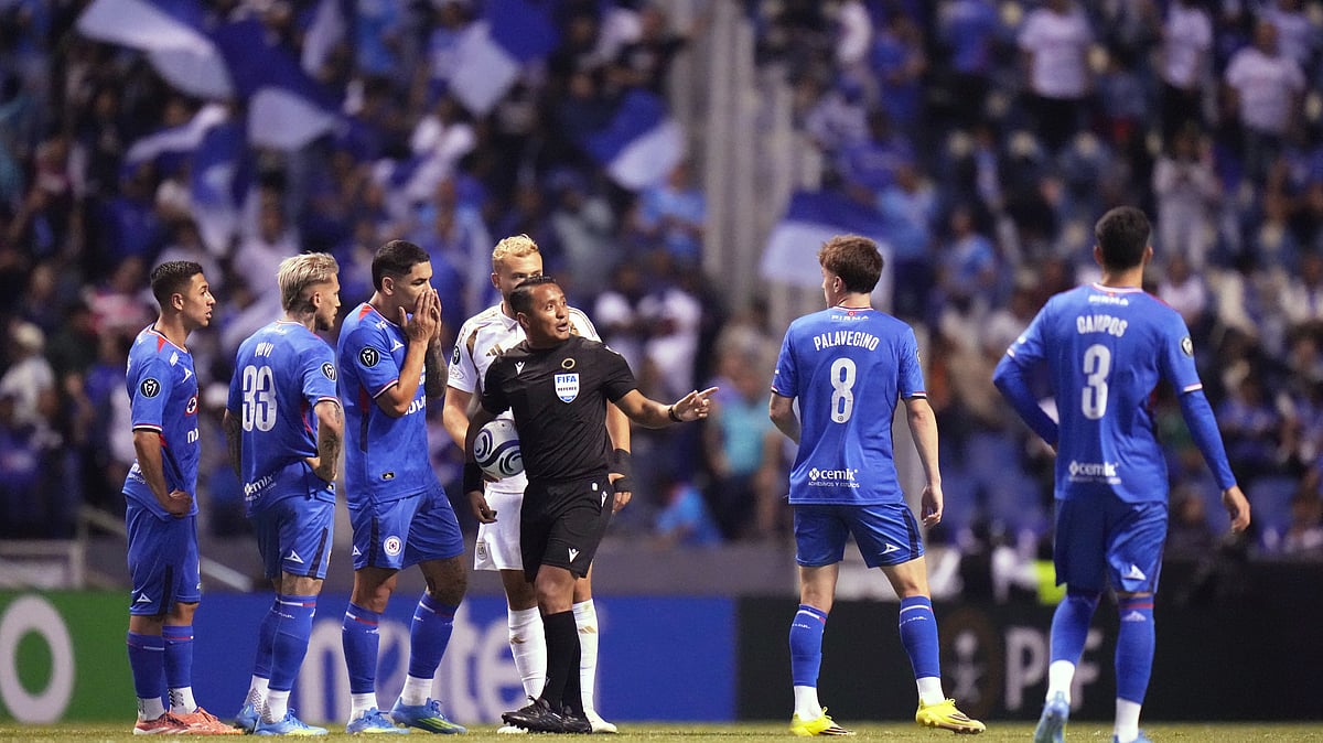 (AP Photo/Eduardo Verdugo) : Referee Ivan Barton suspends the match due to discriminatory chants from the crowd during a CONCACAF Champions Cup quarterfinal second leg soccer match between Mexicos Cruz Azul and the United States Los Angeles FC in Puebla, Mexico, Tuesday, April 14, 2026.