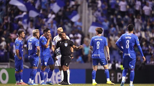 (AP Photo/Eduardo Verdugo) : Referee Ivan Barton suspends the match due to discriminatory chants from the crowd during a CONCACAF Champions Cup quarterfinal second leg soccer match between Mexicos Cruz Azul and the United States Los Angeles FC in Puebla, Mexico, Tuesday, April 14, 2026.