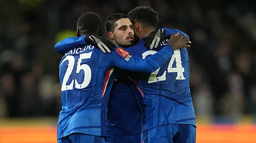 (AP Photo/Jon Super) : Chelseas Moises Caicedo, left, and Reece James hug Pedro Neto after he scored during the English FA Cup fourth round soccer match between Hull City and Chelsea in Hull, England, Friday, Feb. 13, 2026.