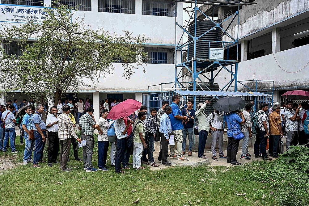 | Photo; PTI : Polling officials wait in queues to cast their votes through postal ballots ahead of the West Bengal Assembly elections, in Phulia, Nadia district.