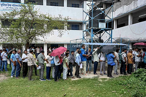 | Photo; PTI : Polling officials wait in queues to cast their votes through postal ballots ahead of the West Bengal Assembly elections, in Phulia, Nadia district.