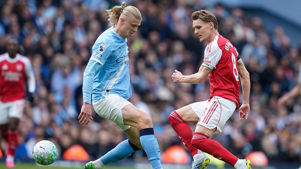 Photo: AP/Dave Thompson : Manchester City's Erling Haaland challenges for the ball with Arsenal's Martin Odegaard during the English Premier League soccer match between Manchester City and and Arsenal, in Manchester, England.