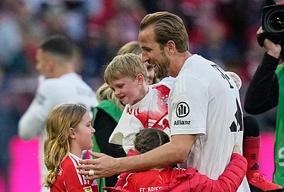 | Photo: AP/Matthias Schrader : Bayerns Harry Kane hugs his kids after his team clinched the German league title after a Bundesliga soccer match between Bayern and Stuttgart in Munich, Germany.