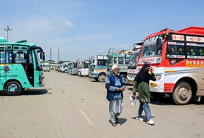 | Photo: PTI : People walk past a bus stand after driver and conductors of private buses stage a protest against the governments proposal to expand Smart City bus services in other districts, in Srinagar, Jammu and Kashmir.