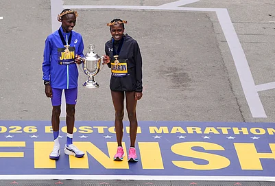 | Photo: AP/Charles Krupa : Boston Marathon winner John Korir of Kenya, left, holds the trophy with womens division winner Sharon Lokedi, also of Kenya, at the finish line of the Boston Marathon, in Boston.