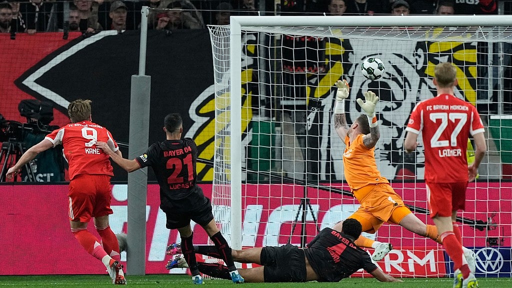 A Photo/Martin Meissner : Bayern's Harry Kane scores his side's opening goal during the German Soccer Cup semifinal match between Bayer Leverkusen and Bayern Munich in Leverkusen, Germany, Wednesday, April 22, 2026.