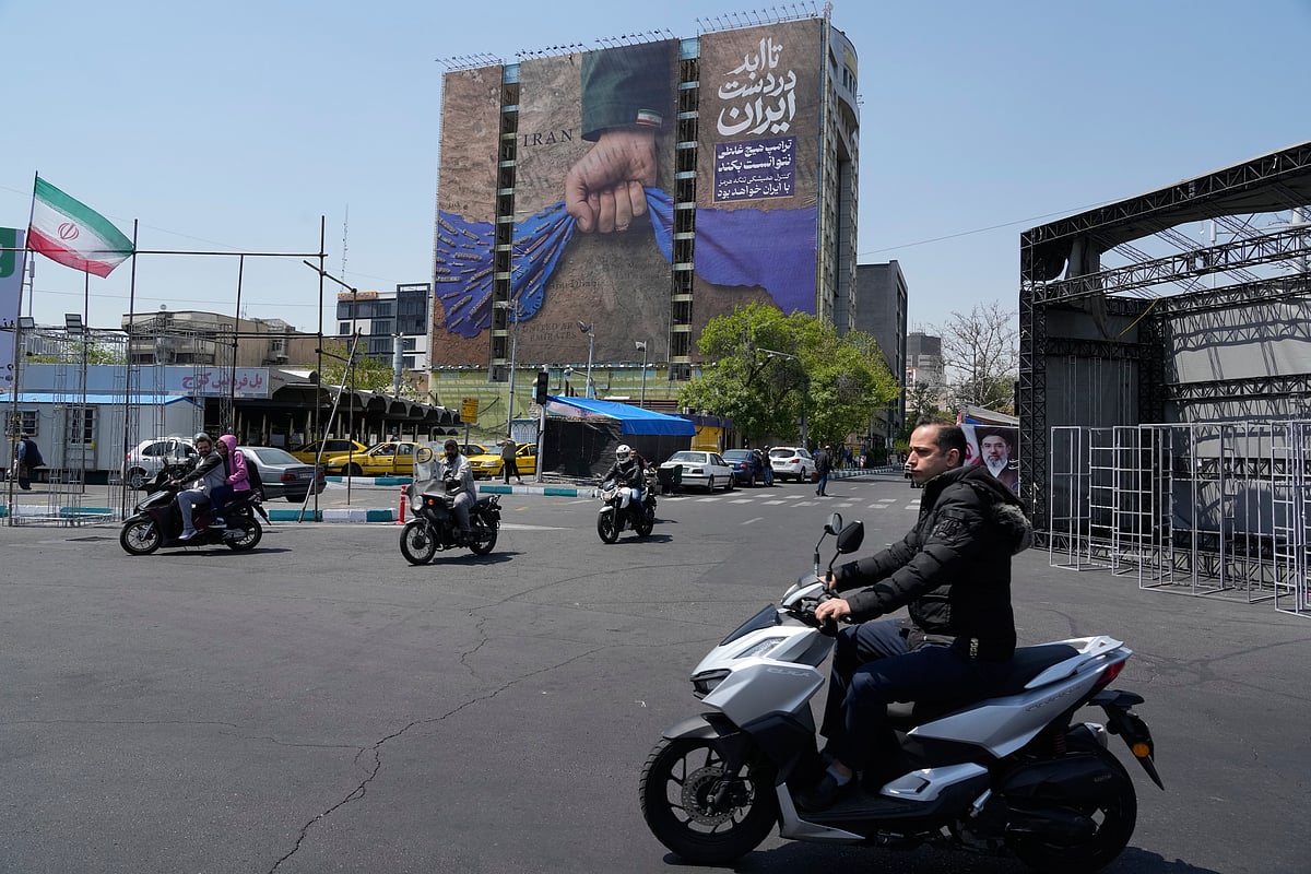 AP  : Motorbikes drive past a billboard that shows a graphic depicting a military personnels hand holding the Strait of Hormuz in his fist with signs which read in Farsi: In Irans hands forever, Trump couldnt do a damn thing, The control of Strait of Hormuz will be Irans forever, in Vanak Square in northern Tehran, Iran, Thursday, April 16, 2026. 