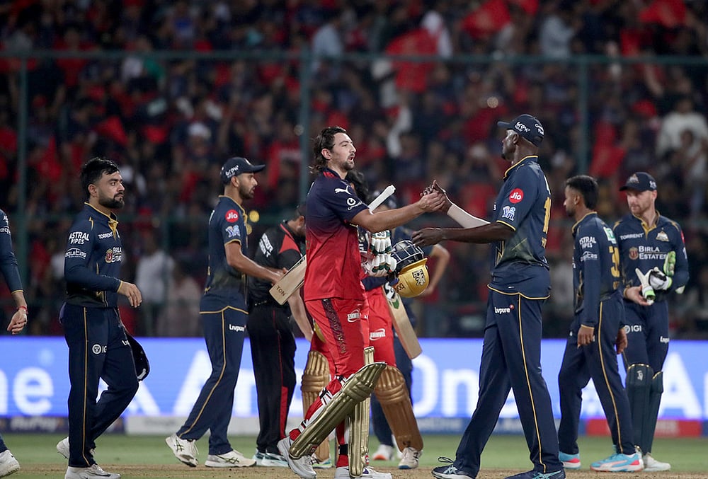 | Photo: AP : Gujarat Titans Jason Holder congratulates Bengalurus Tim David after Royal Challengers Bengaluru won against Gujarat Titans during the Indian Premier League cricket match in Bengaluru.