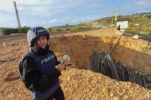 (AP Photo/Mohammed Zaatari) : Lebanese journalist Amal Khalil, who worked for the daily Al-Akhbar newspaper, while reporting near a destroyed bridge in Qasmiyeh, Lebanon, Sunday, March 22, 2026.