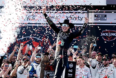 | Photo: AP/Butch Dill : Carson Hocevar celebrates after winning a NASCAR Cup Series auto race, in Talladega, Alabama.