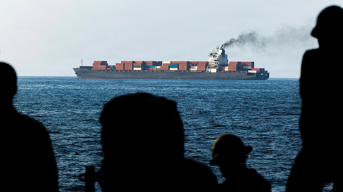 U.S. Navy sailors aboard the San Antonio-class amphibious transport dock ship USS New Orleans look toward the Iranian cargo vessel M V Touska after it was boarded and fired upon for violating the maritime blockade against ships entering or exiting Iranian ports and coastal areas, April 21, 2026, on the Gulf of Oman.