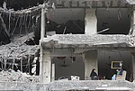 | Photo: AP/Hassan Ammar : The wife and children of Fadi Al Zein, who lost both his homes in Israeli strikes in his village of Khiam and in Dahiyeh, sit on the balcony of their heavily damaged apartment building in Beiruts southern suburbs, Lebanon, Saturday, April 25, 2026.