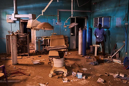 AP : A guard walks through a war-damaged section of Al Shaabi Hospital in Khartoum