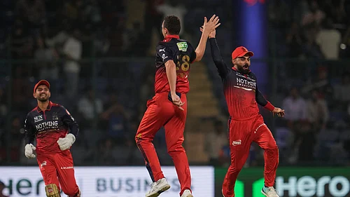 (AP Photo/Manish Swarup) : Royal Challengers Bengalurus Josh Hazlewood, center, and Virat Kohli, right, celebrates the wicket of Delhi Capitals Sameer Rizvi during the Indian Premier League cricket match between Delhi Capitals and Royal Challengers Bengaluru in Delhi, India, Monday, April 27, 2026.