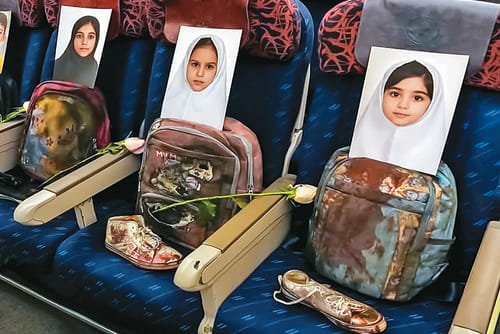 | Photo: Hamed Malekpour : Grounded Lives: An Iranian delegation traveling to Islamabad in April 2026 for peace talks made a symbolic gesture by placing photographs and belongings of children killed in the Minab school strike on empty airplane seats
