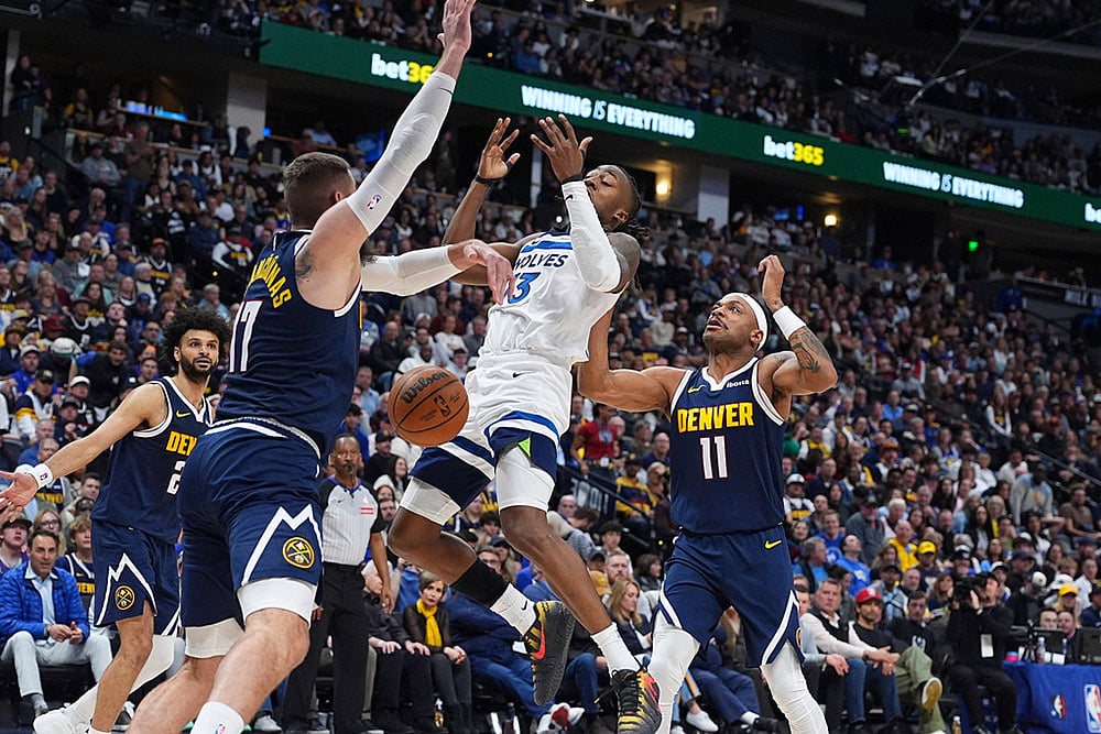| Photo: AP/David Zalubowski : Minnesota Timberwolves guard Ayo Dosunmu, center, loses control of the ball while driving to the net between Denver Nuggets center Jonas Valanciunas, left, and guard Bruce Brown in the second half in Game 5 of a first-round NBA playoffs basketball series in Denver.