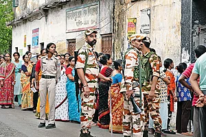 | Photo: Sandipan Chatterjee : Guns and Forces: Voters line up to cast their vote in the second phase of the West Bengal election amid heavy security