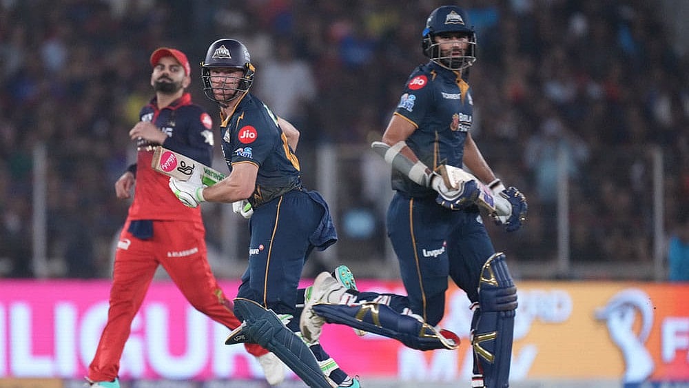 | Photo: AP/Ajit Solanki : Gujarat Titans Washington Sundar, right, and Jos Buttler run between the wickets during the Indian Premier League cricket match between Gujarat Titans and Royal Challengers Bengaluru in Ahmedabad, India.