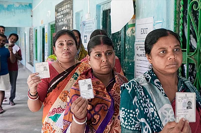 | Photo: PTI/Swapan Mahapatra : Voters shows their identity cards as they wait in a queue to cast their votes at a polling station during a repoll ordered by the Election Commission following reports of electoral malpractices, at Magrahat Paschim constituency, in South 24 Parganas district, West Bengal.