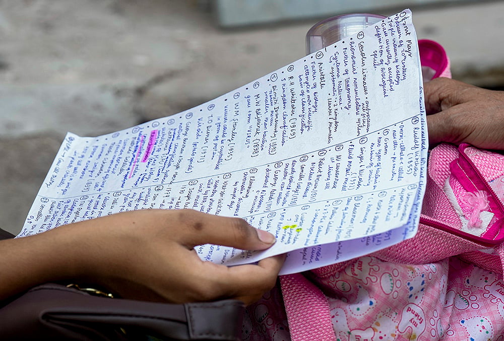 | Photo: PTI/Shahbaz Khan : An aspirant revises from notes before appearing for the National Eligibility-cum-Entrance Test (NEET) UG-2026 examination, at Narela area, in New Delhi.
