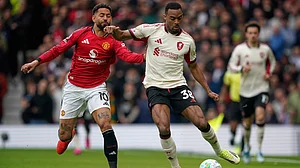 | Photo: AP/Dave Thompson : Manchester United's Matheus Cunha, left, challenges for the ball with Liverpool's Ryan Gravenberch during the English Premier League soccer match between Manchester United and Liverpool in Manchester, England, Sunday, May 3, 2026.