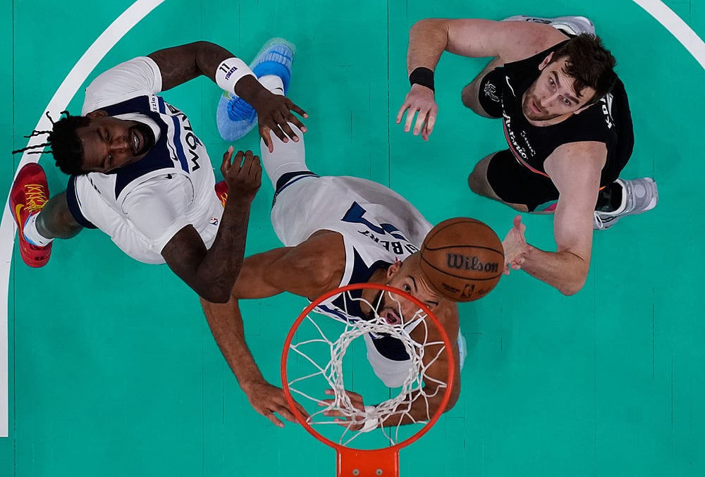 | Photo: AP/Eric Gay : Minnesota Timberwolves center Naz Reid, left, center Rudy Gobert, center, and San Antonio Spurs center Luke Kornet, right, eye a rebound during the first half in Game 1 of a second-round NBA playoffs basketball series in San Antonio.
