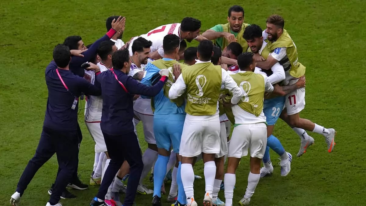 File : Iran players celebrate their team's first goal against Wales.